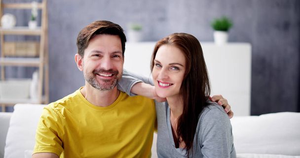 Portrait Of Happy Couple Sitting On Couch - Foto, imagen
