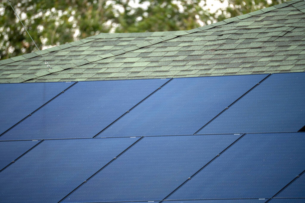 Ilmakuva tyypillinen amerikkalainen rakennus katto sininen aurinkosähkö paneelit tuottaa puhdasta ekologista sähköenergiaa. Uusiutuvaan sähköön investoiminen eläketuloa varten. - Valokuva, kuva