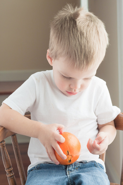 Niño pelando naranja
 - Foto, Imagen