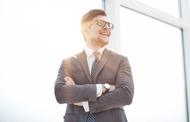 Portrait of a young businessman wearing glasses and standing in office - Foto, afbeelding