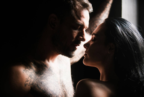 Couple of young lovers kissing. Young couple of attractive woman and naked muscular man kissed in studio background. Couple in love. Beautiful lovers kiss - Fotoğraf, Görsel