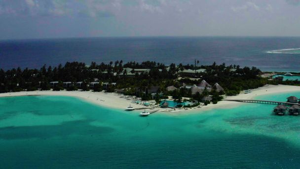 Antenni video drone lentää yli viehättävä ranta valkoista hiekkaa ja sinistä vettä, palmuja ja meren aallot. - Valokuva, kuva