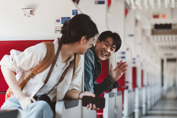 Pareja asiática en un tren tienen un momento feliz. Turismo y viajes en verano. - Foto, imagen