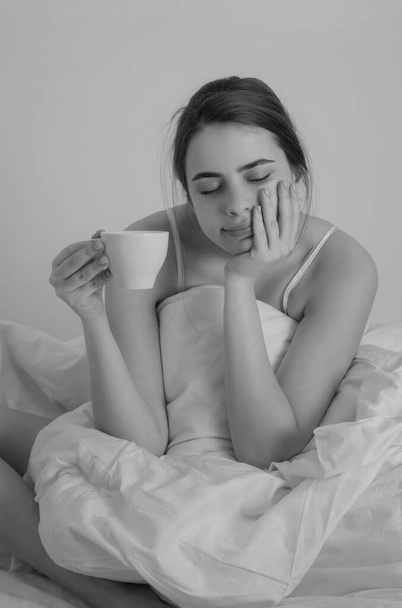 Woman with morning coffee on the bed - Fotoğraf, Görsel