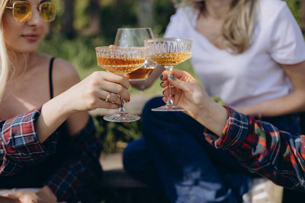The girls hands hold delicious summer cocktails raise them for a cheers - Фото, изображение