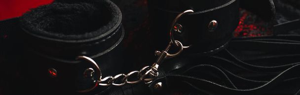 Handcuffs and a whip with womens sexy underwear. Concept of sex toys for BDSM with submission and domination. Panoramic wide horizontal photo for banner head cover - Photo, Image