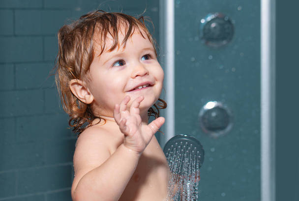 Toddler in a bathtub. Funny baby kid bathed in foam and washing in bathtub at home - Foto, Bild
