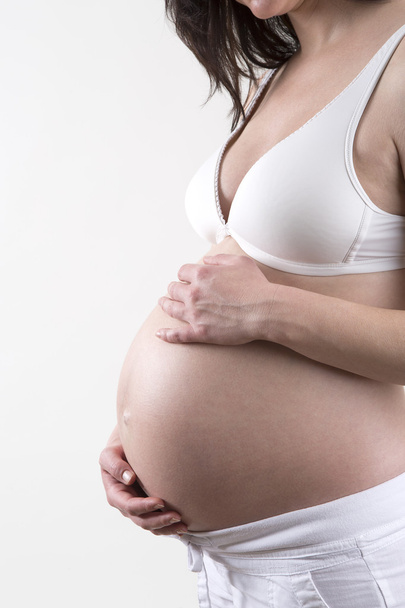 Έγκυος γυναίκα μπροστά από ένα λευκό φόντο - Φωτογραφία, εικόνα