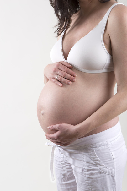 Schwangere vor weißem Hintergrund - Foto, Bild