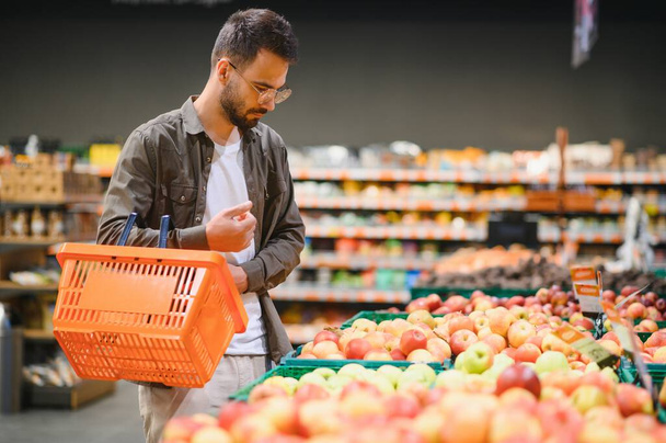 Uomo acquistare verdure e frutta in sacchetto riutilizzabile in negozio di alimentari, zero rifiuti concetto. - Foto, immagini