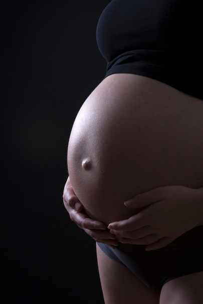 Schwangere vor schwarzem Hintergrund - Foto, Bild