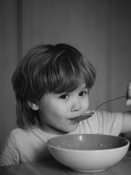 Kid eating. Little boy having breakfast in the kitchen. Food and Drink for Child. Kid boy eating healthy food at home - Foto, immagini