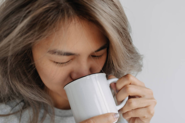Asian woman drink coffee in the morning on the bed. High quality photo - Foto, afbeelding