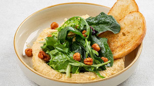 Portion Gourmet-Hummus mit Grünzeug und Toasts - Foto, Bild