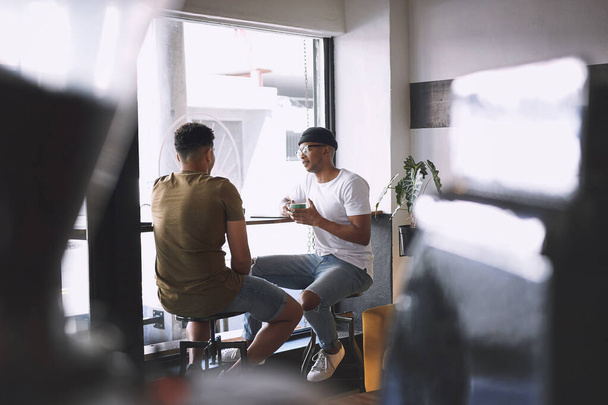 Je suis content qu'on se soit rencontrés pour un café. deux jeunes hommes parlent tout en prenant un café ensemble dans un café - Photo, image