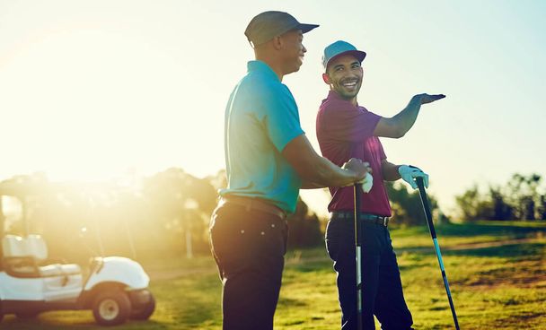 Aprendes algo nuevo cada día. dos amigos jugando una ronda de golf en un campo de golf - Foto, Imagen