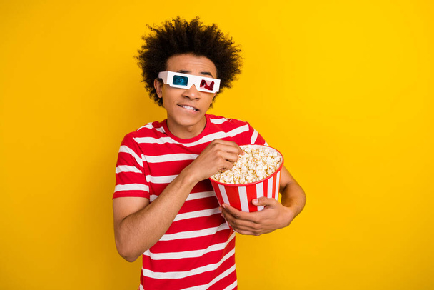 Portrait of nervous man eat popcorn bite lips watch movie 3d glasses isolated on yellow color background. - Fotografie, Obrázek