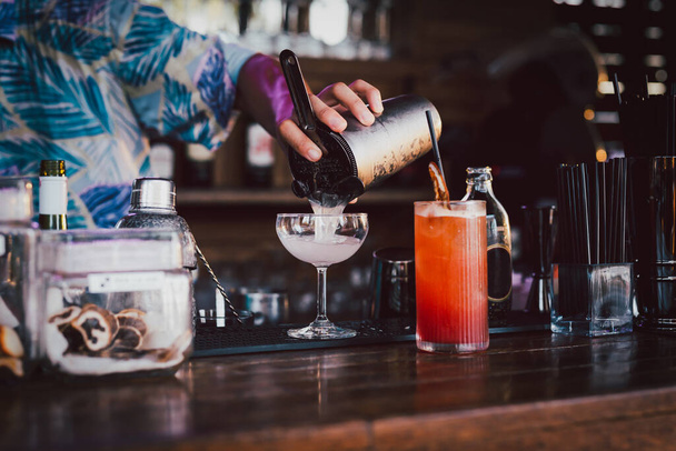Barman robi koktajl wlewający się do kieliszka martini - Zdjęcie, obraz