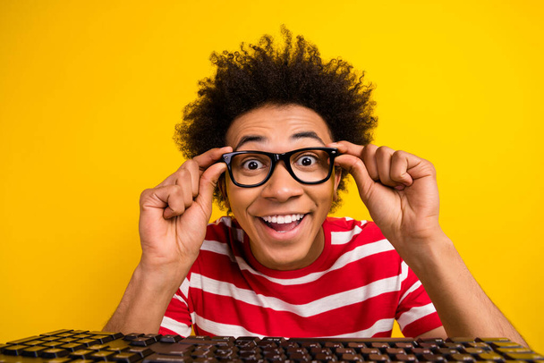 Portrait cheerful funky person hands touch eyeglasses beaming smile pc keyboard isolated on yellow color background. - Zdjęcie, obraz