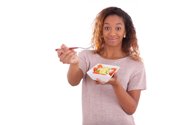 Mujer afroamericana comiendo ensalada, aislada sobre fondo blanco
 - Foto, imagen