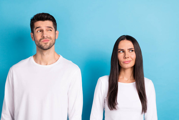 Photo portrait of cute young man woman look skeptical unsure empty space wear trendy white clothes isolated on blue color background. - Foto, imagen