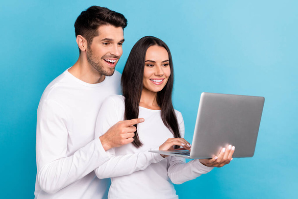 Photo of attractive young male female apple macbook samsung users promo dressed stylish white outfit isolated on blue color background. - Foto, Bild