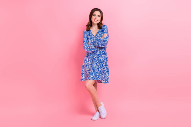 Full length photo of cheerful woman with wavy hairdo wear blue dress arms folded look empty space isolated on pink color background. - Foto, afbeelding