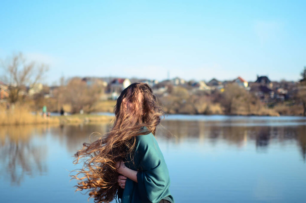 Wind blows on hair.Hair fell over her face. Girl with long curly hair. - Photo, Image