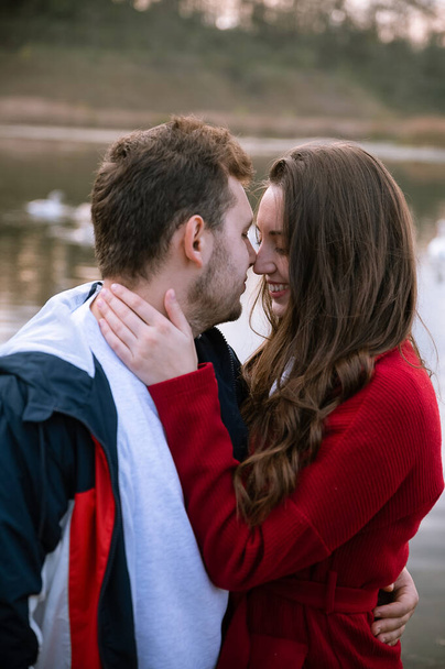 young couple enjoying romantic time in nature.Photo for valentine's day.Real couple of lovers.True emotions.People hugging.Face to face.Romance between people.Woman with long hair hugs a man.Beautiful couple of lovers.The couple hugs in nature.love. - Zdjęcie, obraz