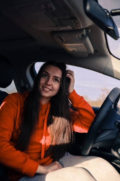 woman sitting inside the car seat.Woman sitting in the car.Girl driver of the auto.Beautiful woman in the car.Woman smiling in the car.Renting a car.Comfortable interior of the auto.buying a first auto.self-sufficient woman.feminism.woman dreams - Valokuva, kuva