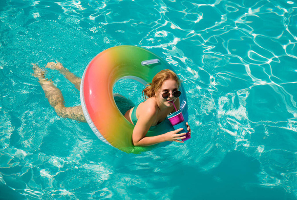 Summer Vacation. Enjoying suntan. Woman in swimsuit on inflatable circle in the swimming pool - Φωτογραφία, εικόνα