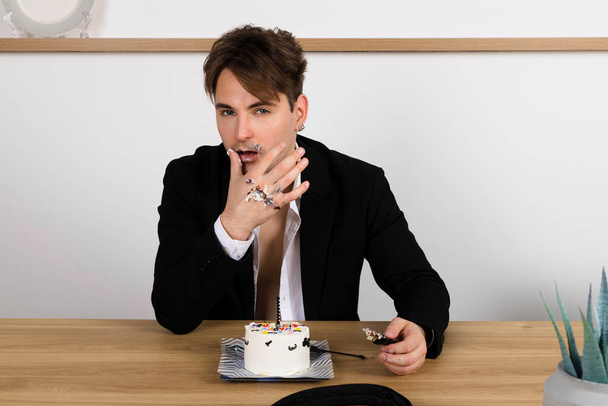 drunk businessman casually celebrating his birthday, slices and eating a cake, made a mess - Photo, image