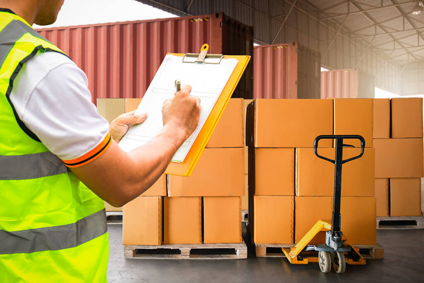 作業者は、配布倉庫のロードパッケージボックスを確認するクリップボードを保持します。お客様への配送。倉庫、貨物トラック、倉庫物流輸送 - 写真・画像