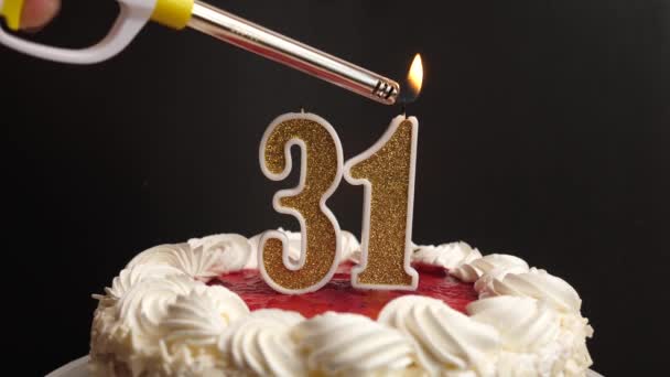 Uma vela na forma do número 31, inserida no bolo de férias, é acesa. Celebrar um aniversário ou um evento marcante. O clímax da celebração. - Filmagem, Vídeo
