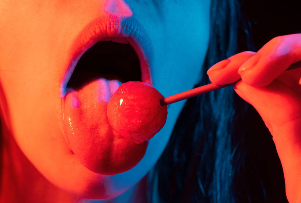Close up lips with lollipop isolated, sexy blowjob, sensual mouth with lipstick eats sweets. Sexy design for women and girls. Beautiful lips - Foto, imagen