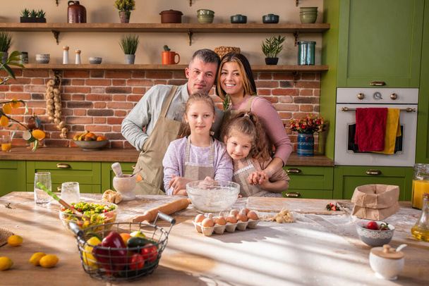 Portrait of a beautiful family members very charismatic posing at the home in the kitchen they looking straight to the camera and smiling large. - 写真・画像