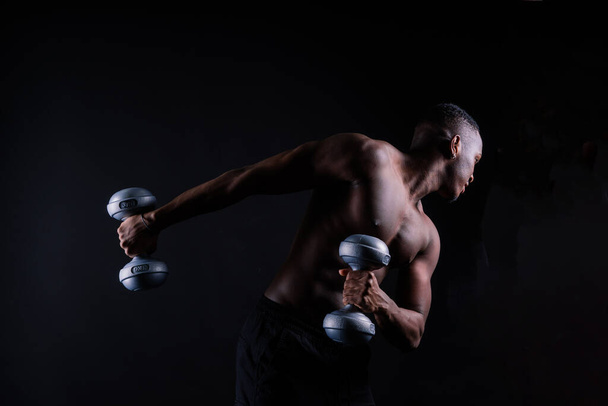 Спортсмен афроамериканський чоловік топлес, великі м'язи, студія темного фону
 - Фото, зображення