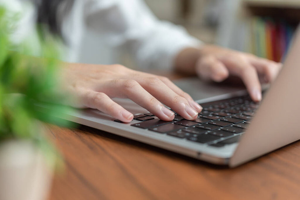 женщина печатает на клавиатуре ноутбука, ищет информацию или делает внештатную работу.Цифровые технологии онлайн сети и концепции социальных медиа. - Фото, изображение