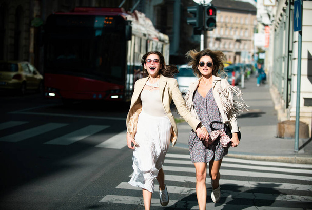 Two excited happy women walking running together on the street. Funny vacation, romantic travel - Foto, imagen