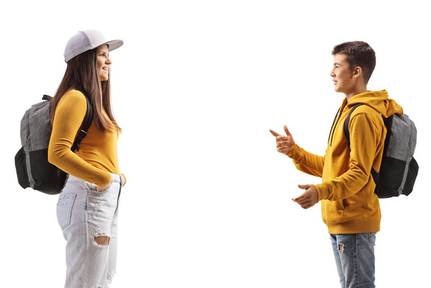 Profile shot of a male teenager talking to a female student isolated on white background - Zdjęcie, obraz