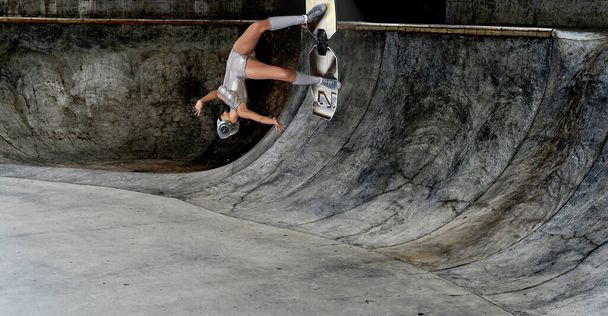 Uma menina monta e faz truques em um skate na rampa de um parque de skate. Renderização 3D - Foto, Imagem
