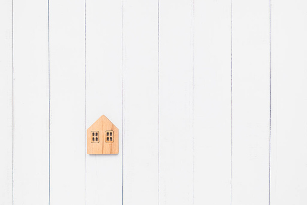 Colocación plana del modelo de casa de madera sobre fondo de mesa blanco para vivienda y concepto de propiedad - Foto, Imagen