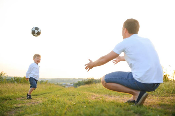 father's day. Dad and son playing together outdoors on a summer. Happy family, father, son at sunset - Фото, зображення