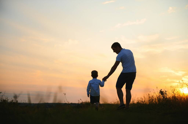father's day. Dad and son playing together outdoors on a summer. Happy family, father, son at sunset - Φωτογραφία, εικόνα