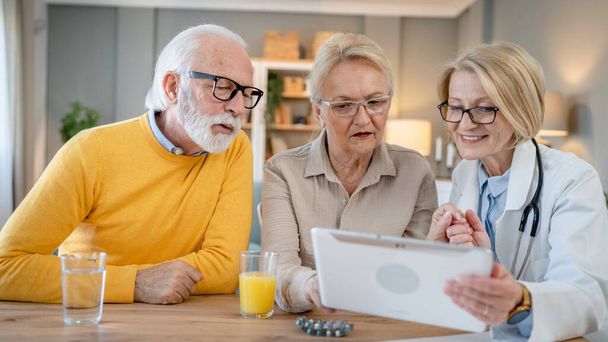 Mature woman doctor visit senior couple man and female husband and wife having a talk and consulting about diagnosis and medical medication treatment real people healthcare concept copy space - Photo, image