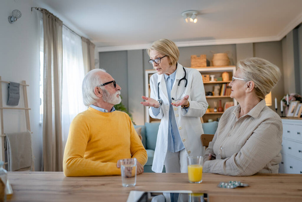 Mature woman doctor visit senior couple man and female husband and wife having a talk and consulting about diagnosis and medical medication treatment real people healthcare concept copy space - Φωτογραφία, εικόνα