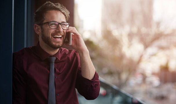 Dobré komunikační dovednosti jsou nezbytné pro obchodní úspěch. mladý podnikatel používající mobilní telefon na balkóně kanceláře - Fotografie, Obrázek
