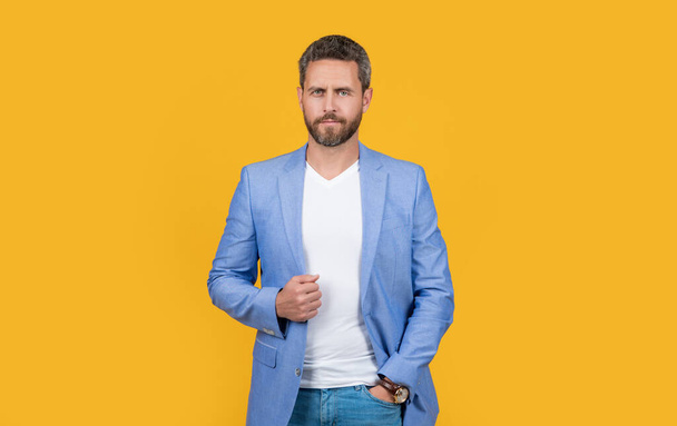 caucasian man in studio. photo of handsome man wear suit. man wearing formal jacket. caucasian man in jacket isolated on yellow background. - Φωτογραφία, εικόνα