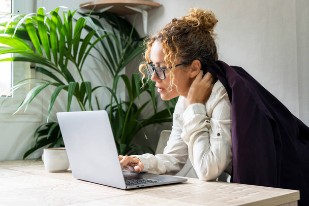 менеджер женщина работает на ноутбуке в офисе. Предпринимательница пользуется компьютером на рабочем месте. Концепция альтернативного нового бизнеса онлайн людей в помещении. Занятая леди - Фото, изображение