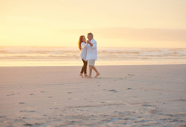 Den Ruhestand wegromantisieren. ein reifes Paar tanzt am Strand - Foto, Bild